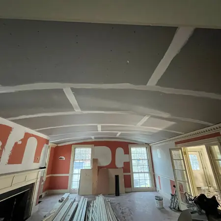 Curved ceiling boarded out, with board stacked ready for the next room