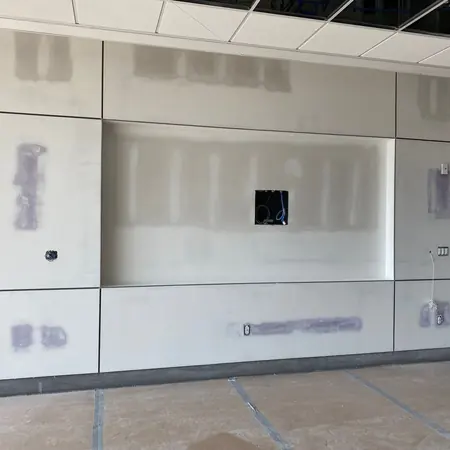 Base coat applied and levelled across a commercial interior wall